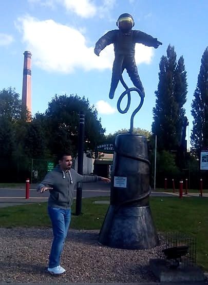Nikos in Leicester, mid pose next to an astronaut sculpture.